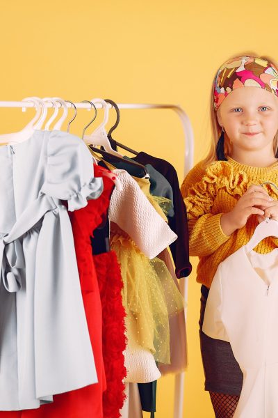 Child with shopping bags. Lady in a yellow sweater. Little designer